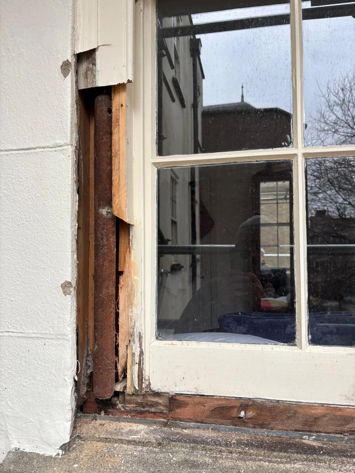 Exposed timber beside a sash window during frame repair.
