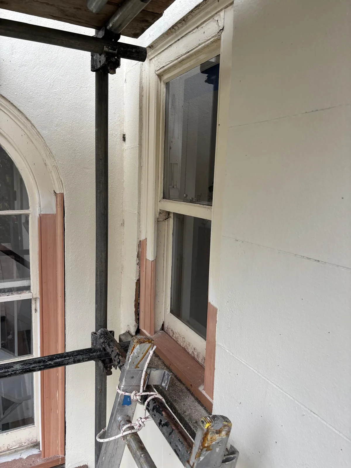 Scaffold access beside sash window during timber repairs.