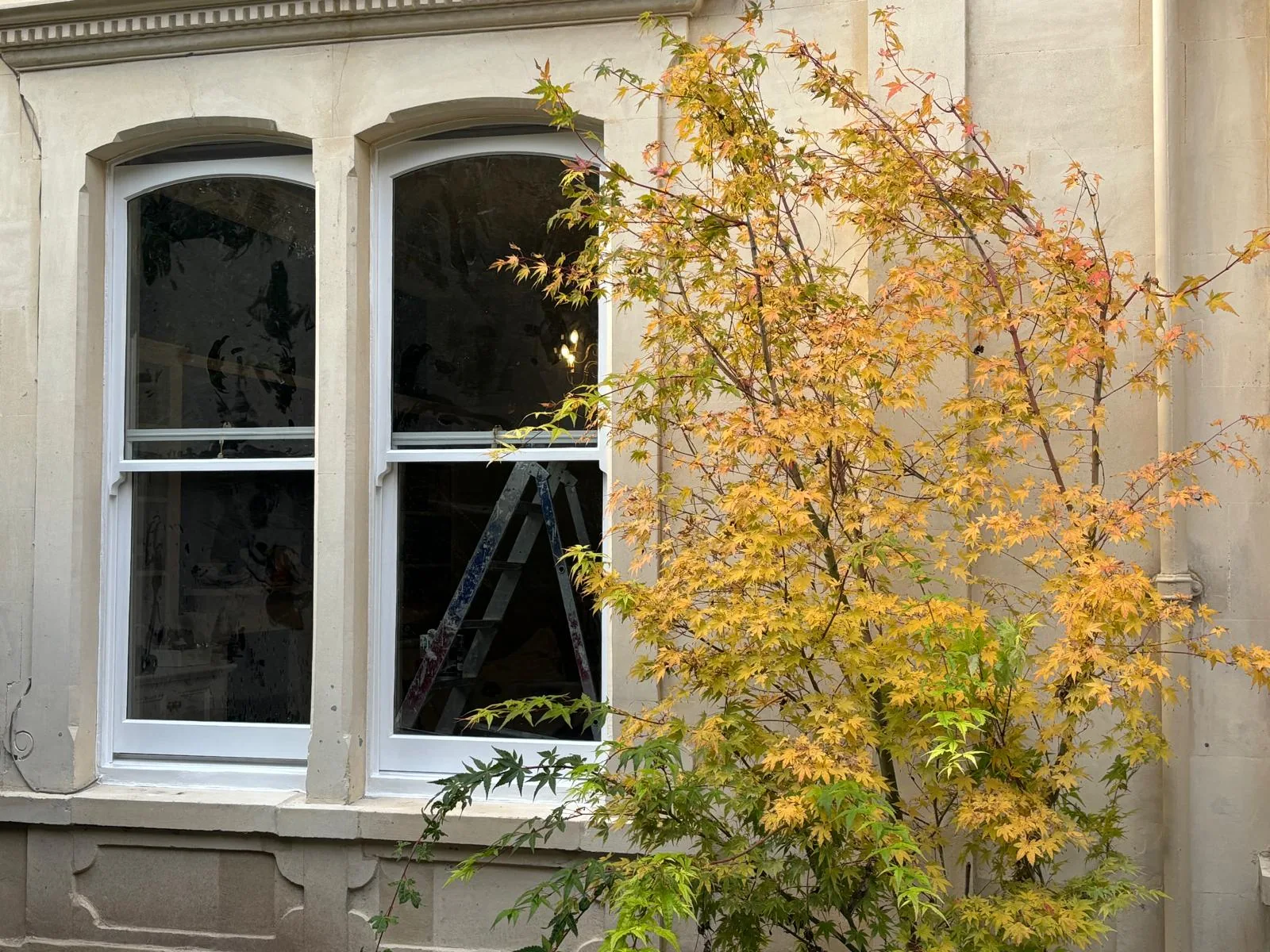 New double-glazed sash windows on a period stone facade.