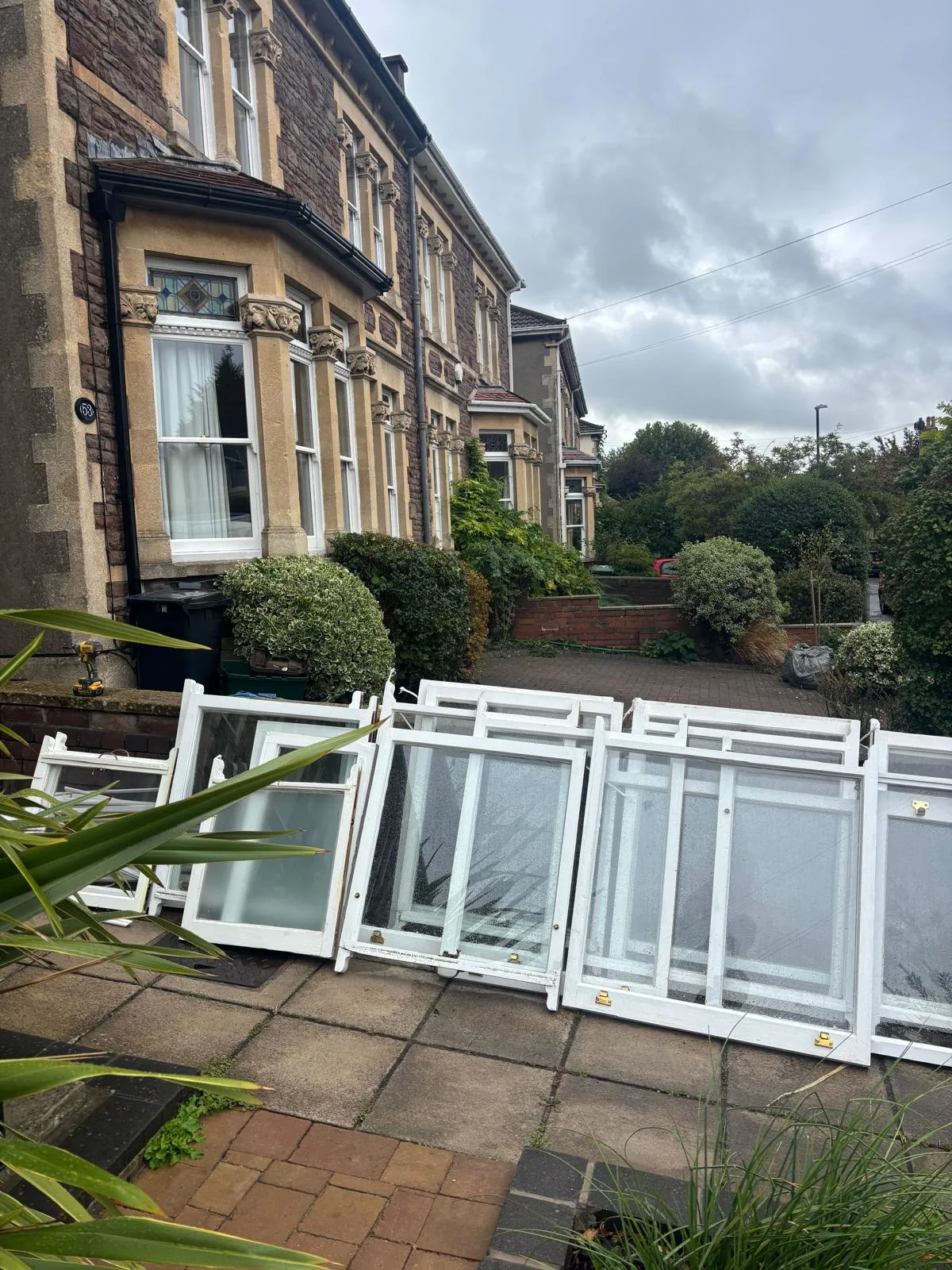 Replacement double glazed sashes stacked outside a period property.