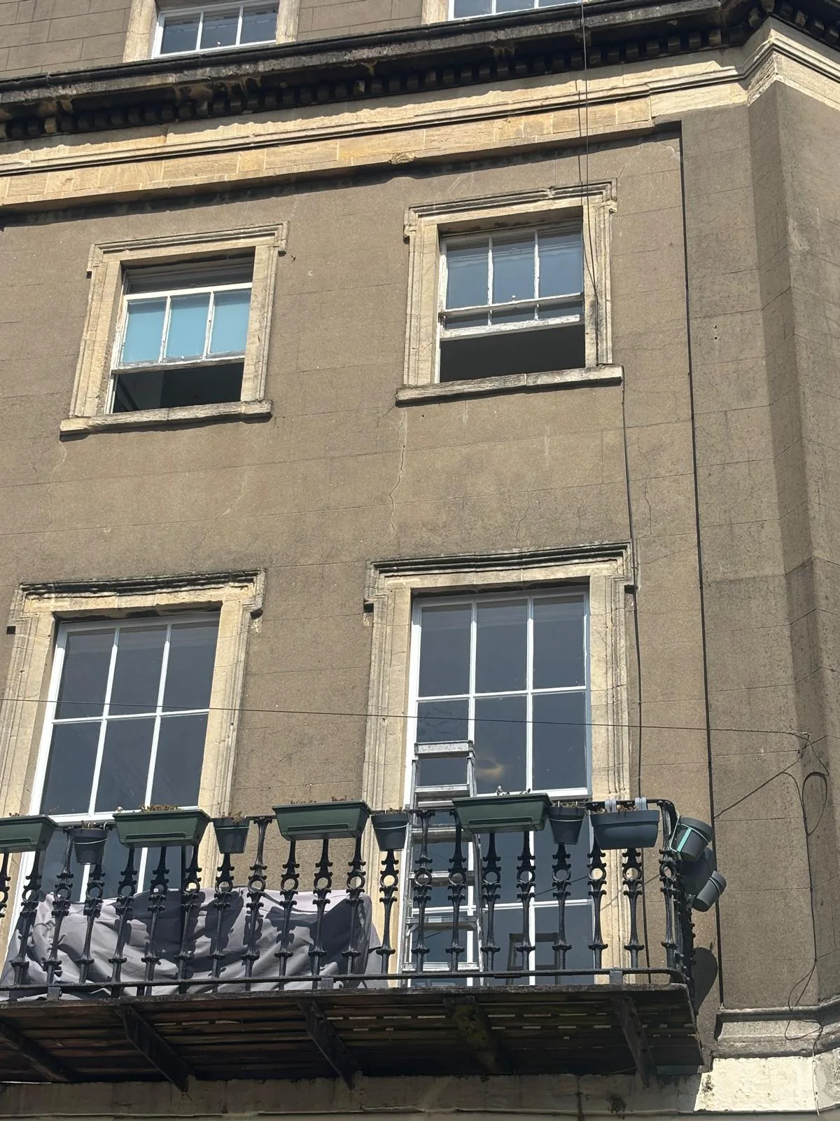 Upper-storey period facade with sash windows and balcony.
