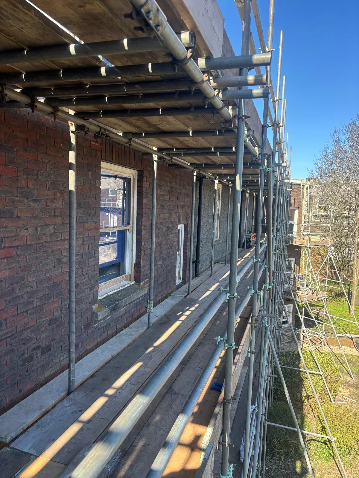 Scaffolded period facade showing a repaired sash window.