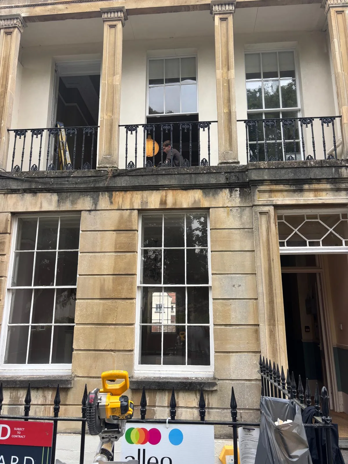 Scaffolded historic stone facade with sash windows.