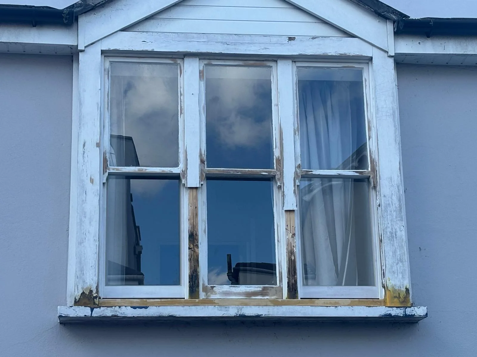 Weathered white sash window before refurbishment.