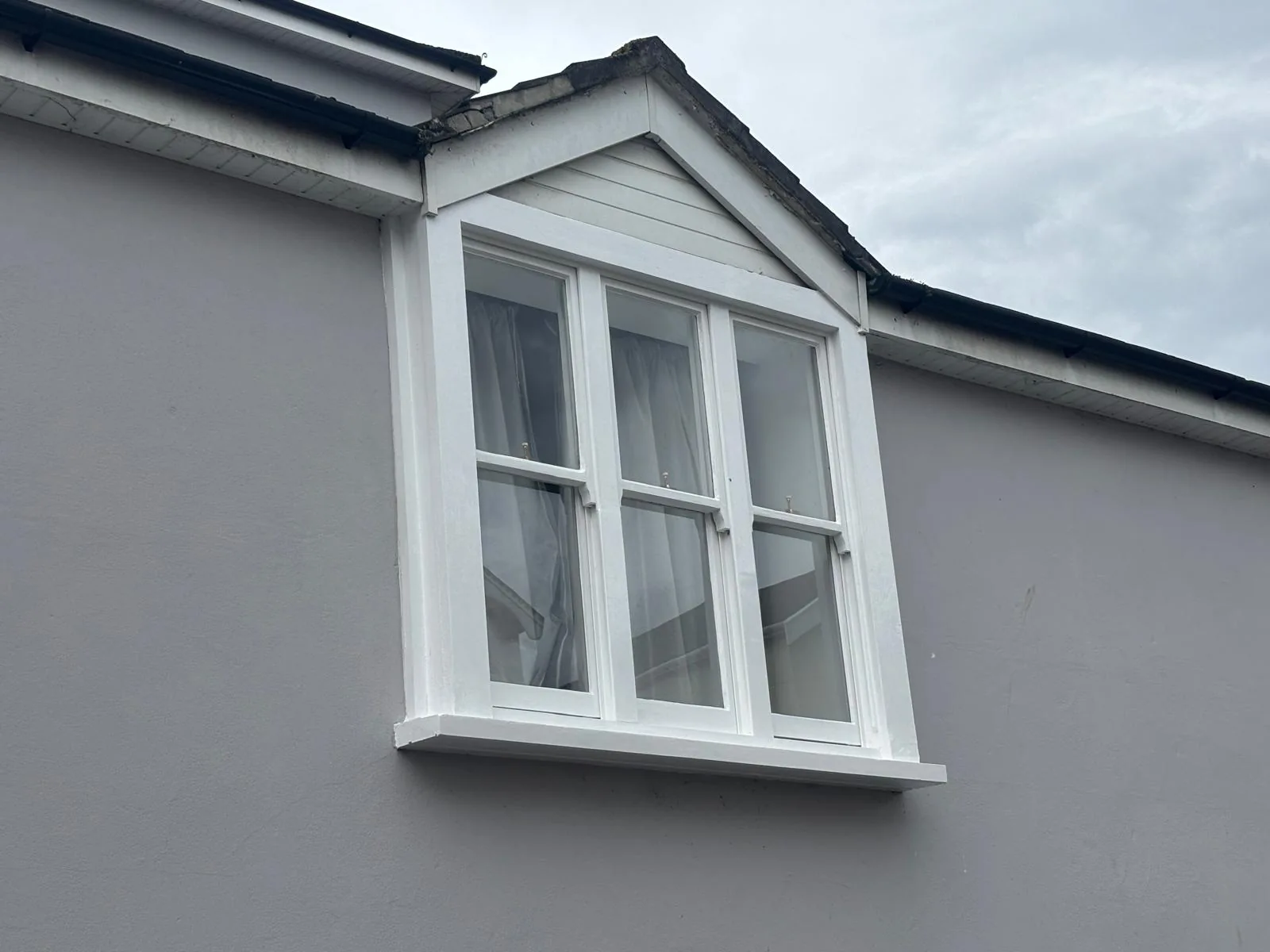 Completed white sash window in a gable end.